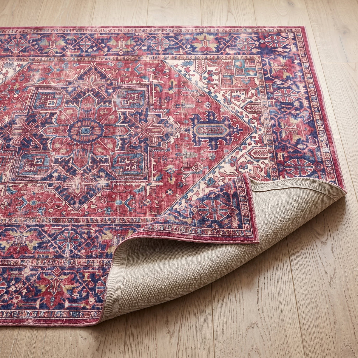 Mulberry Persian-style rug with one corner turned back to show the non-slip backing